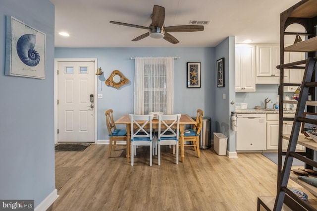 dining space with sink, ceiling fan, and light wood-type flooring