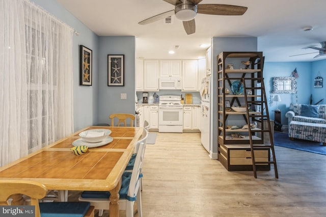 dining room with ceiling fan and light hardwood / wood-style floors