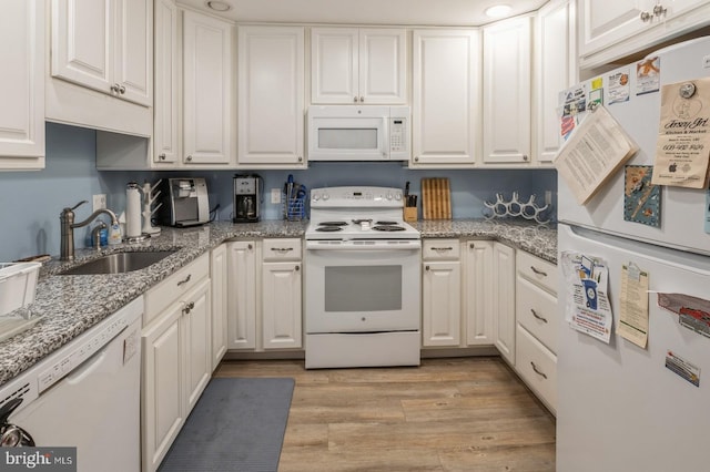 kitchen with sink, white cabinetry, light stone counters, light hardwood / wood-style flooring, and white appliances