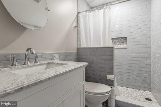 bathroom featuring toilet, vanity, and walk in shower