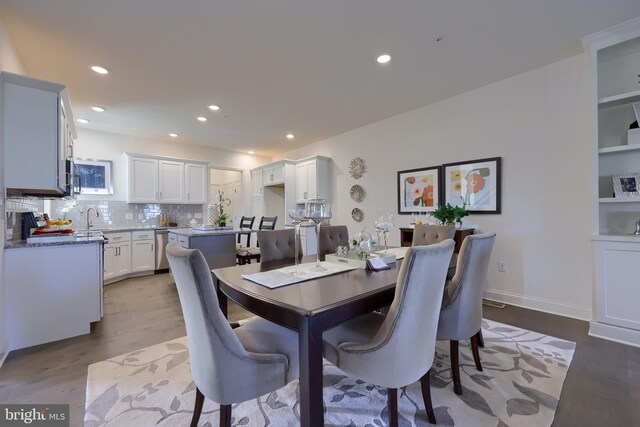 dining space featuring light wood-type flooring and sink