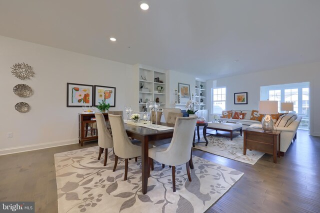 dining area featuring built in shelves and hardwood / wood-style floors