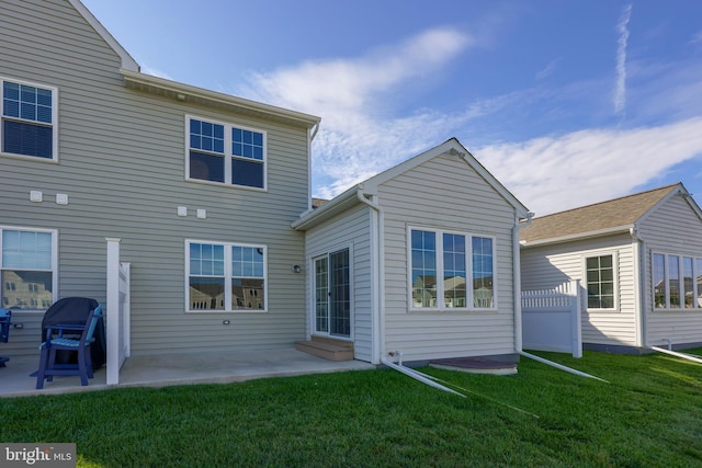 rear view of property with a yard and a patio area