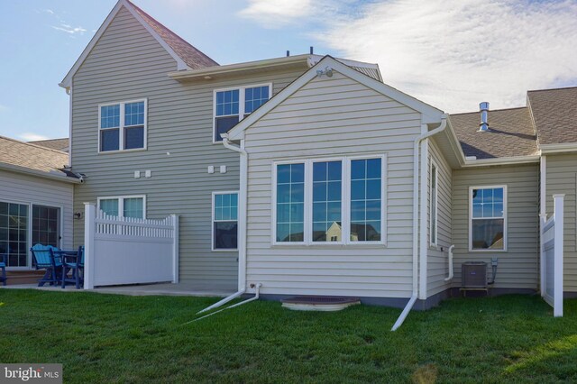 rear view of property with central AC, a patio area, and a yard