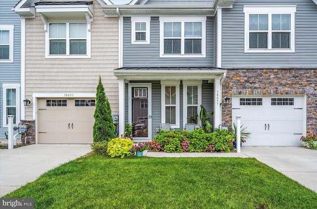 view of property featuring a garage and a front lawn