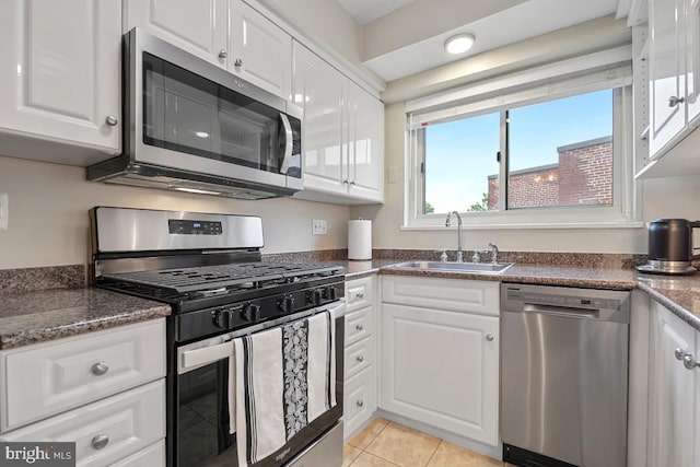 kitchen featuring stainless steel appliances, white cabinets, light tile patterned flooring, and sink