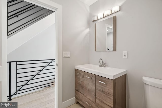 bathroom featuring hardwood / wood-style flooring, vanity, and toilet