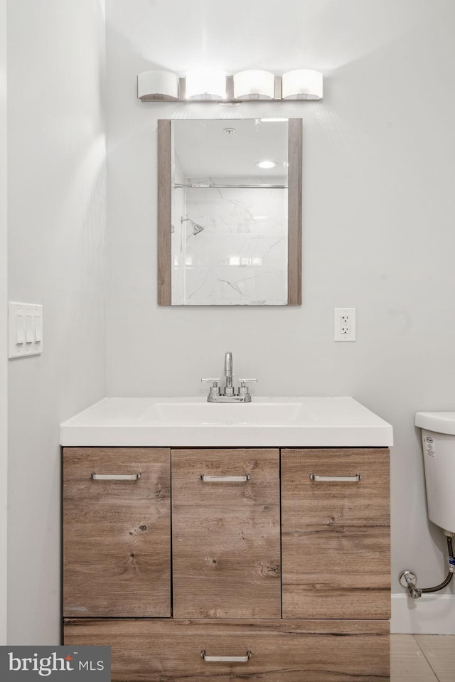 bathroom featuring tile patterned flooring, vanity, and toilet