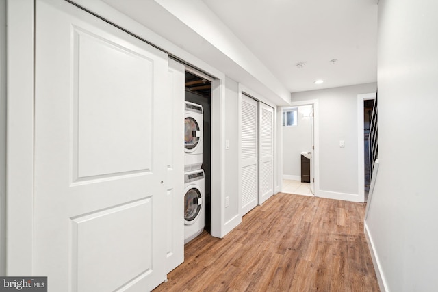 interior space featuring stacked washer and dryer and light hardwood / wood-style flooring