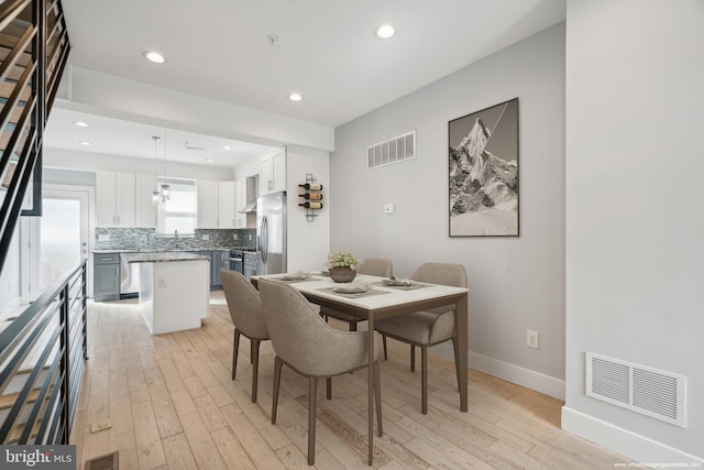 dining space featuring sink and light hardwood / wood-style flooring