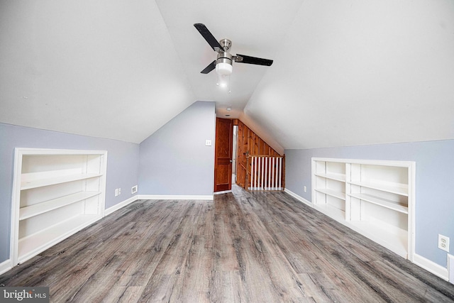 bonus room with ceiling fan, built in features, wood-type flooring, and lofted ceiling