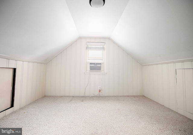 additional living space featuring carpet flooring, wooden walls, cooling unit, and lofted ceiling