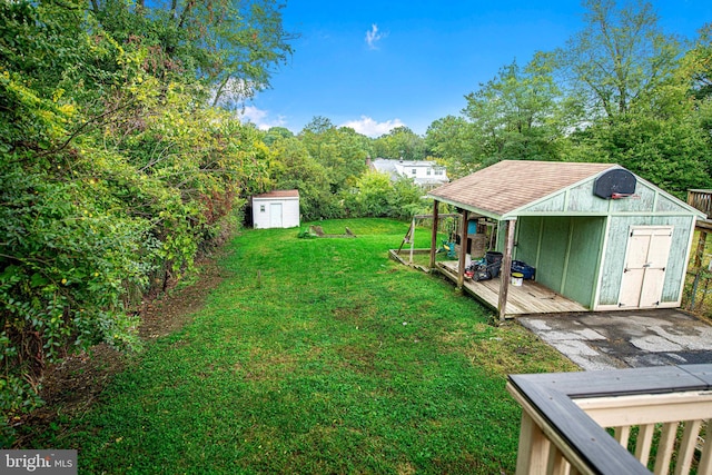 view of yard with a wooden deck and a storage unit