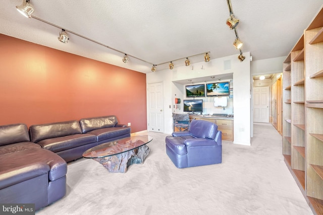 carpeted living room with rail lighting and a textured ceiling