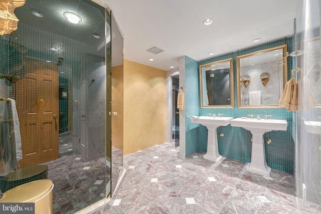 bathroom featuring tiled shower and sink