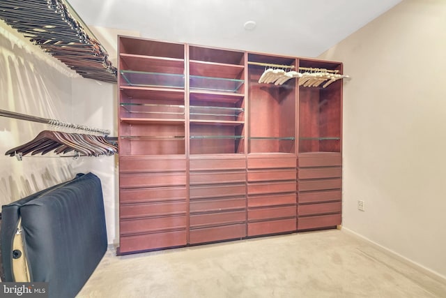 walk in closet featuring light colored carpet