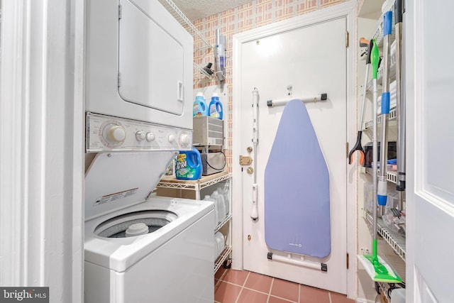 laundry room with tile patterned floors, stacked washer / dryer, and a textured ceiling