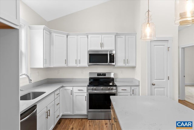 kitchen featuring decorative light fixtures, sink, stainless steel appliances, and white cabinetry