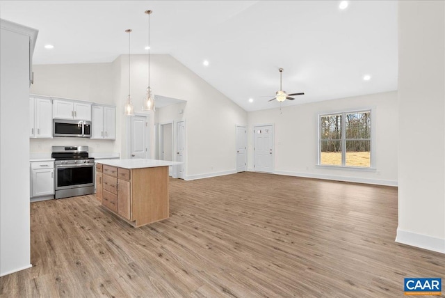 kitchen featuring ceiling fan, a center island, pendant lighting, white cabinetry, and appliances with stainless steel finishes