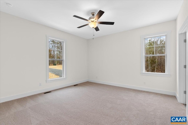 carpeted spare room featuring ceiling fan