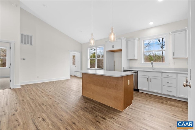 kitchen featuring white cabinetry, stainless steel dishwasher, and a center island