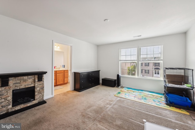 game room featuring light colored carpet and a fireplace