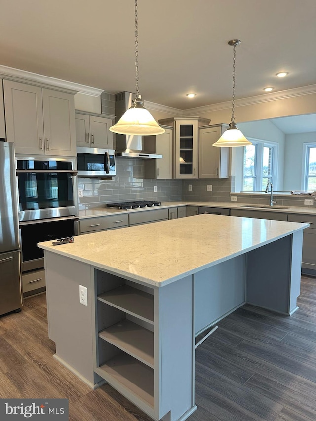 kitchen with hanging light fixtures, a center island, stainless steel appliances, and dark hardwood / wood-style flooring