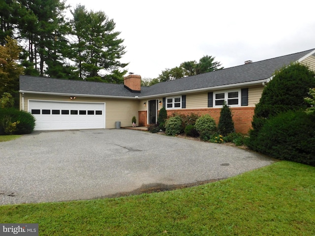 ranch-style house featuring a garage and a front lawn