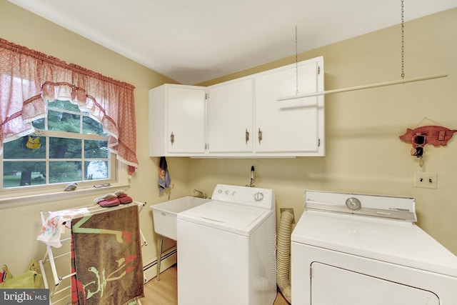 laundry area with cabinet space, independent washer and dryer, a baseboard heating unit, and light wood-type flooring