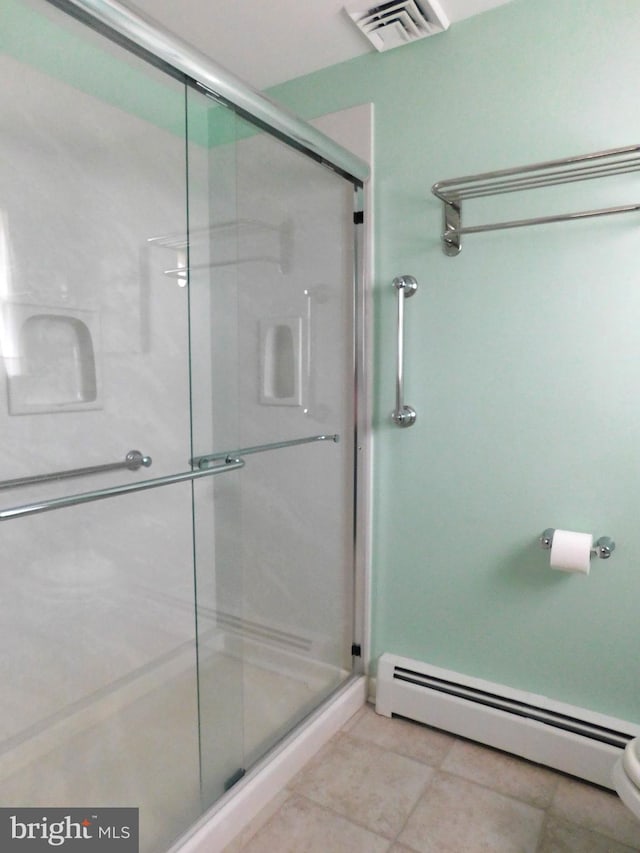 bathroom with walk in shower, baseboard heating, and tile patterned flooring