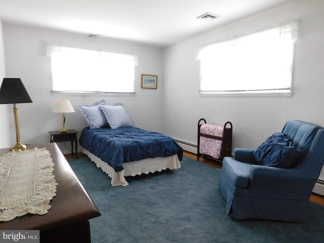 carpeted bedroom with a baseboard heating unit