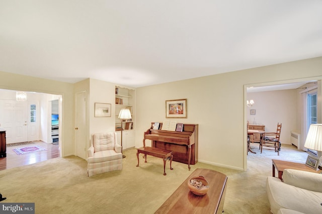 living room with light carpet, a chandelier, healthy amount of natural light, and baseboards