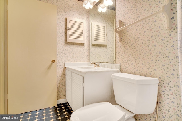 bathroom featuring wallpapered walls, toilet, and vanity