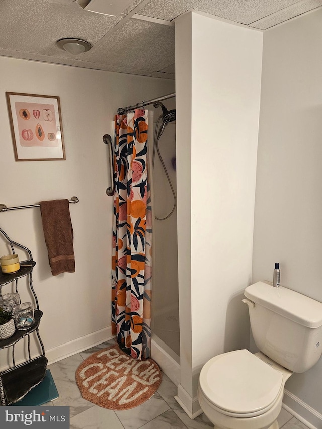 bathroom featuring toilet, curtained shower, and baseboards