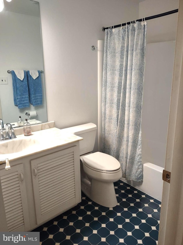 bathroom featuring tile patterned floors, toilet, vanity, and shower / bath combo