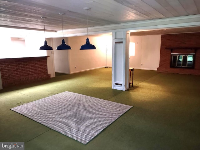 finished below grade area featuring carpet flooring, baseboards, brick wall, and a brick fireplace
