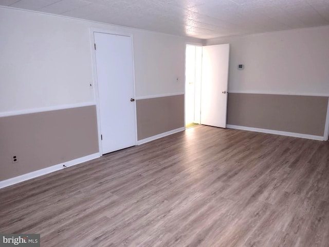 empty room featuring wood finished floors and baseboards