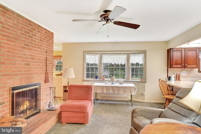 living area with healthy amount of natural light, a ceiling fan, a brick fireplace, and baseboards