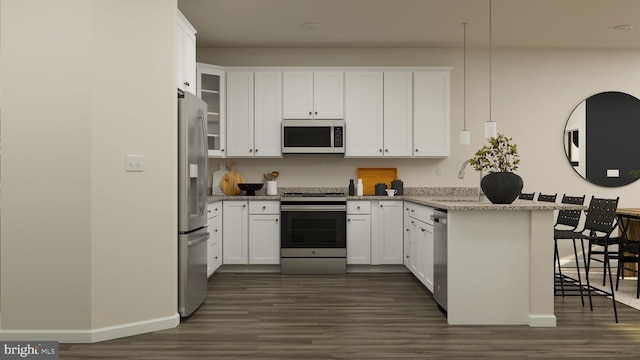 kitchen with light stone counters, appliances with stainless steel finishes, a kitchen breakfast bar, and white cabinetry