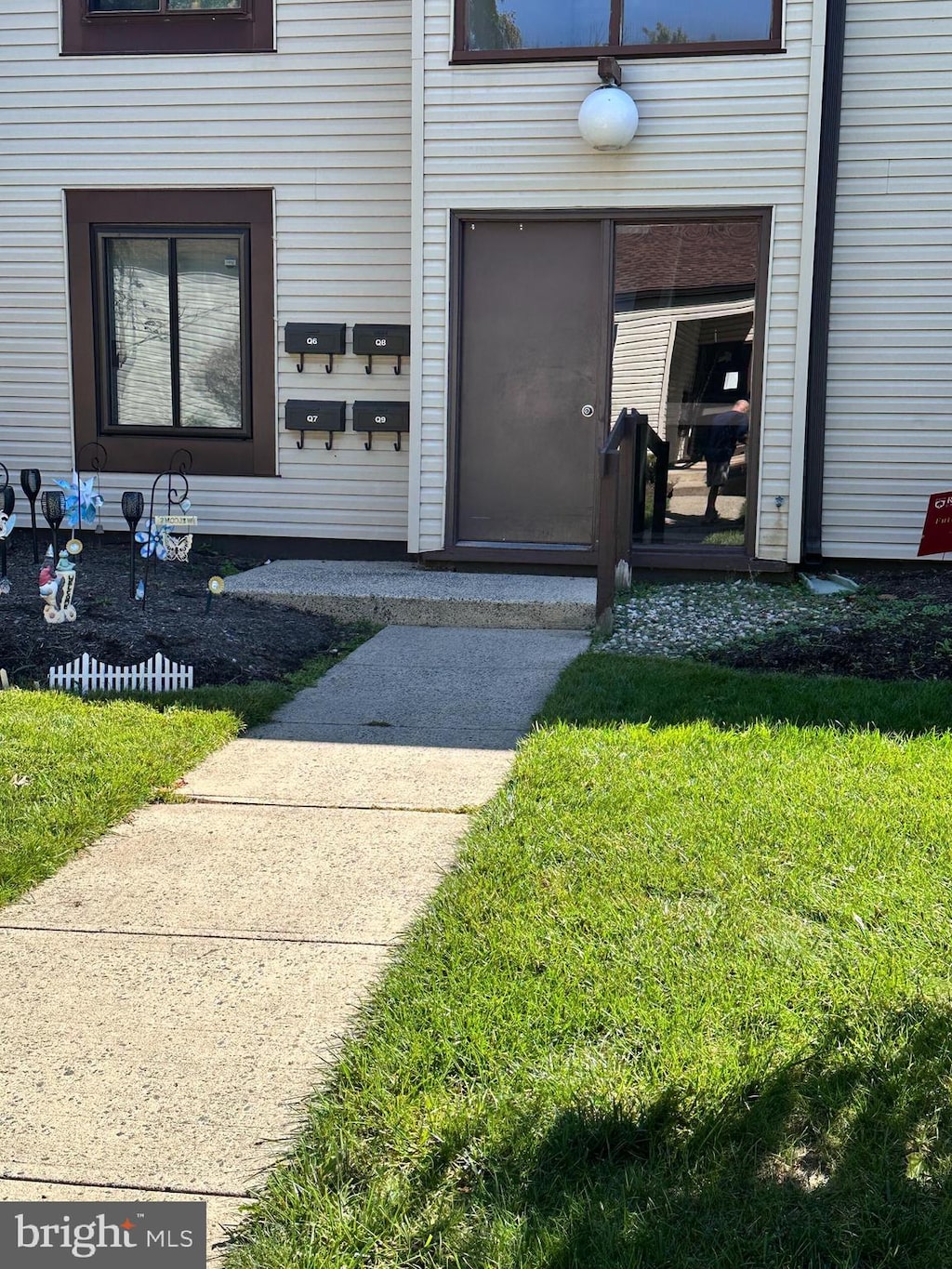 entrance to property featuring a lawn