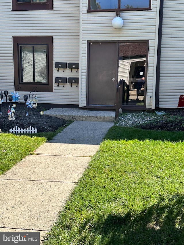 entrance to property featuring a lawn