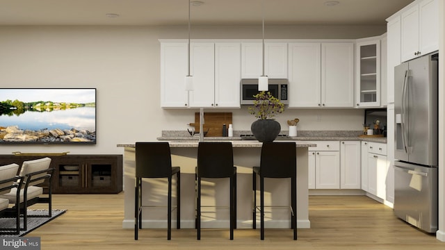 kitchen featuring white cabinetry, a center island, stainless steel appliances, and a breakfast bar