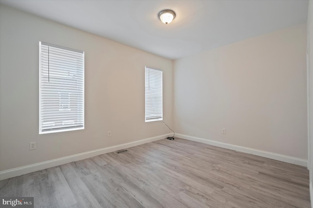 unfurnished room featuring light wood-type flooring and plenty of natural light