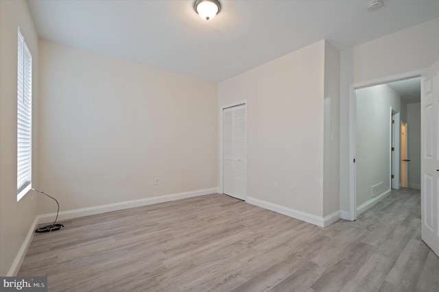 unfurnished bedroom featuring a closet and light hardwood / wood-style floors