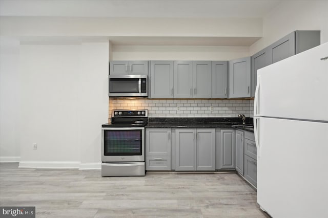 kitchen featuring stainless steel appliances, backsplash, and light hardwood / wood-style flooring