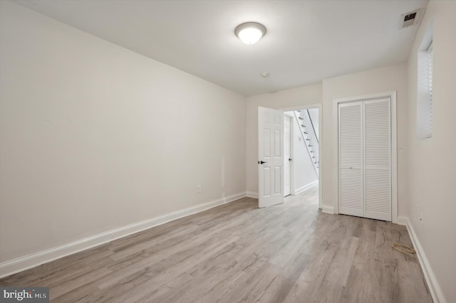 unfurnished bedroom featuring light wood-type flooring and a closet