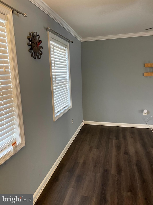 empty room with dark hardwood / wood-style floors and crown molding