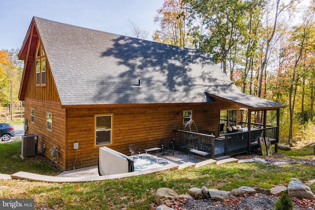 back of property with cooling unit, a wooden deck, and a patio