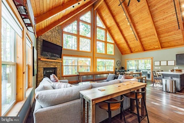 living room featuring wooden ceiling, wood-type flooring, a fireplace, and high vaulted ceiling