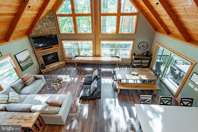 living room featuring a stone fireplace, wood ceiling, dark wood-type flooring, and beamed ceiling